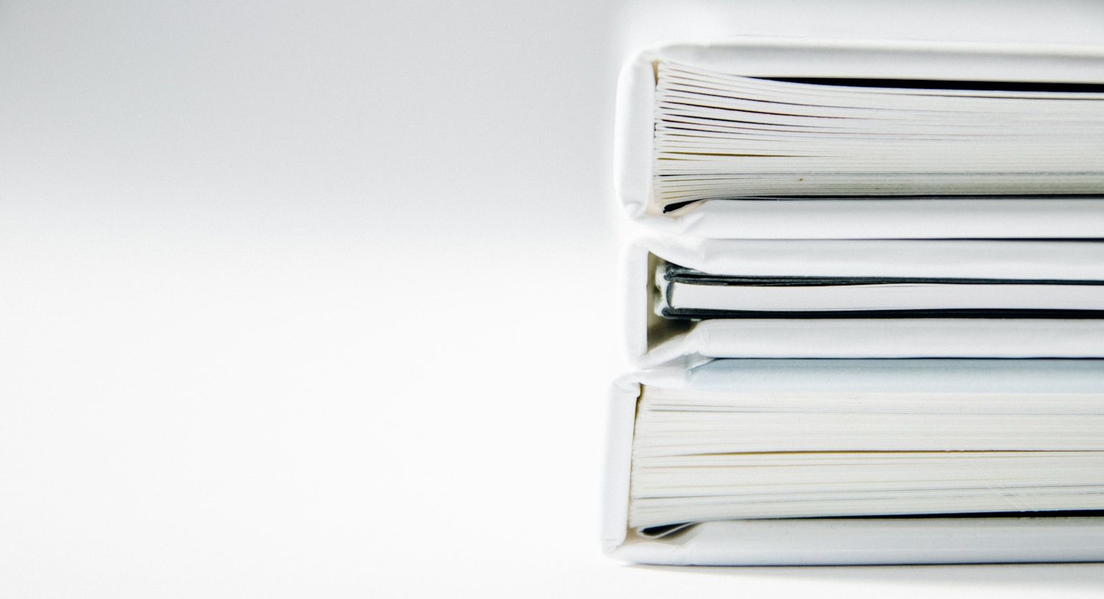 Pila ordenada de expedientes y carpetas sobre un fondo claro